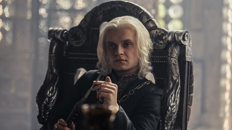 Aegon holding knife in chair