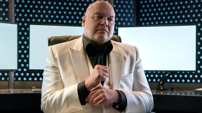 Kingpin seated wearing white suit